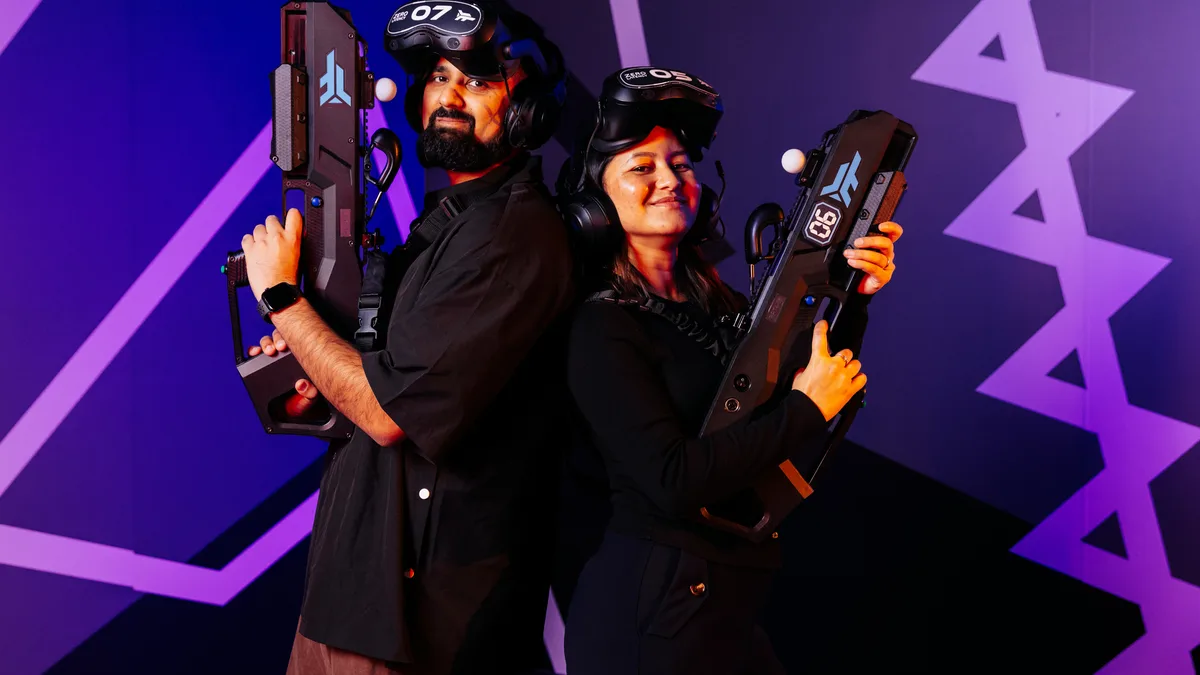 Couple standing back to back holding VR blasters at Zero Latency