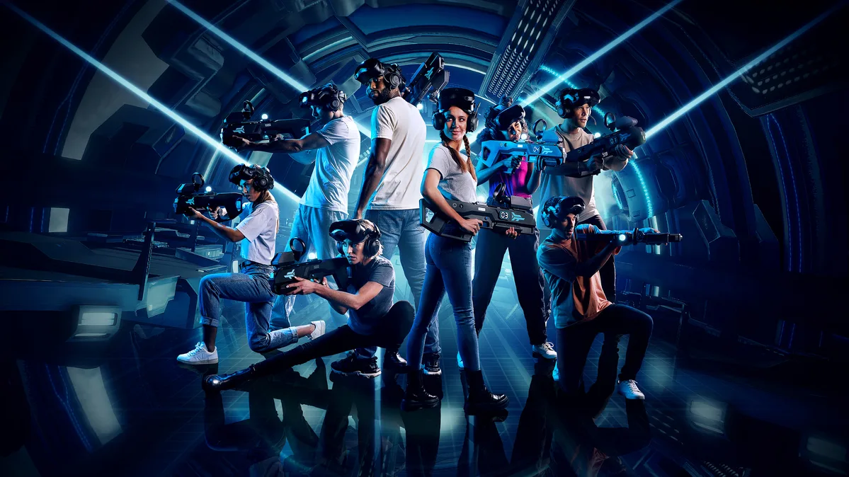 Eight players in wireless VR headsets moving through a sci-fi corridor in free-roam VR